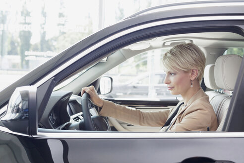 Beim Autohändler, Frau sitzt in neuem Auto - MLF000050