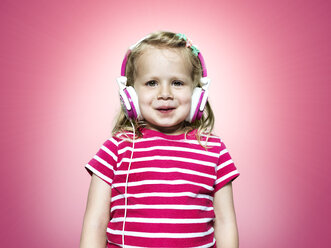 Lächelndes junges Mädchen hört Kopfhörer - STKF000347