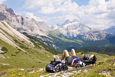 Italien, Südtirol, Dolomiten, Naturpark Fanes-Sennes-Prags, Wanderer liegend auf Almwiese - UM000649