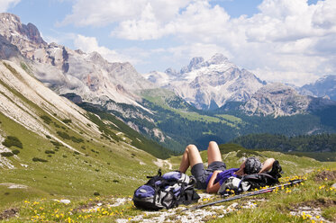 Italy, South Tyrol, Dolomites, Fanes-Sennes-Prags Nature Park, hiker lying in alpine meadow - UM000649