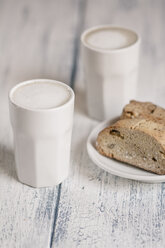 Cups of latte macchiatto with almond biscuits on wooden board - SBDF000179