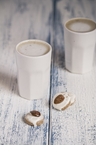 Tassen mit Latte Macchiatto und Mandelgebäck auf Holzbrett, lizenzfreies Stockfoto