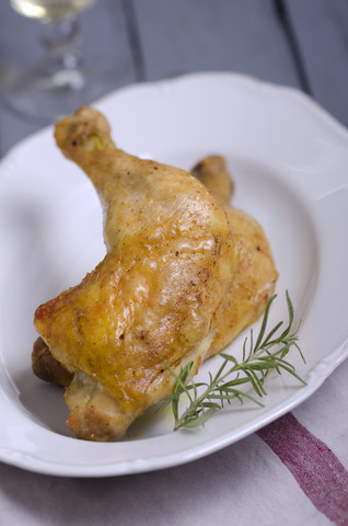 Teil eines mit Mais gefütterten Huhns aus dem Ofen auf einem Teller, lizenzfreies Stockfoto