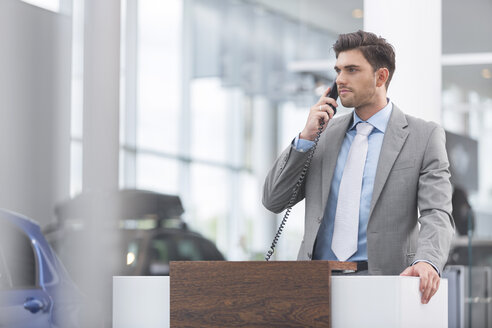 Autohändler am Telefon im Ausstellungsraum - MLF000001