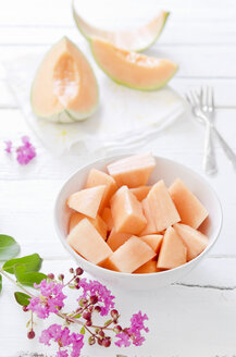 Pieces and slices of charentais melon on white wooden table - CZF000080
