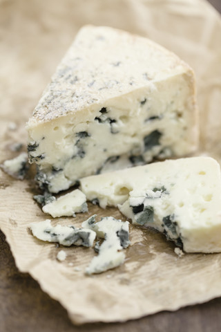 Stück Roquefort-Käse auf Papier, Nahaufnahme, lizenzfreies Stockfoto