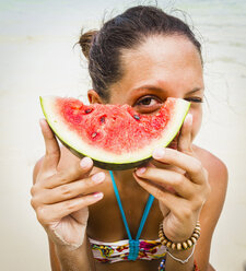 Thailand, Insel Koh Surin, Frau hält am Strand eine Scheibe Wassermelone in den Händen, Nahaufnahme - MBEF000732