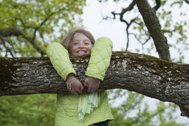 Deutschland, Bayern, Mädchen klettert auf einen Baum - CRF002483