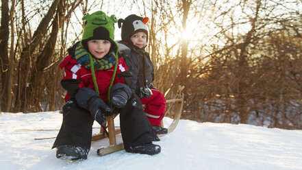 Germany, Munich, Two boys sitting on toboggan - RDF001157