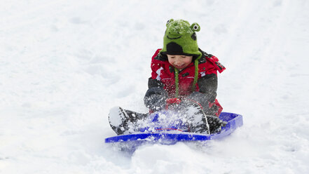 Germany, Bavaria, smiling little boy sledging down a hill - RDF001166