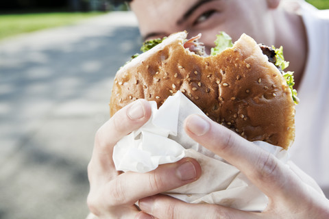 Young man showing his hamburger stock photo