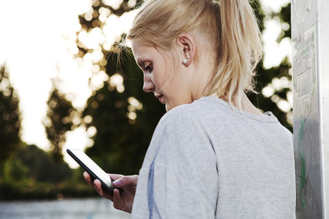 Smiling young woman with smart phone stock photo