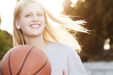 Smiling young woman with basketball - FEXF000049
