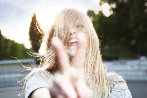 Young woman showing victory sign stock photo