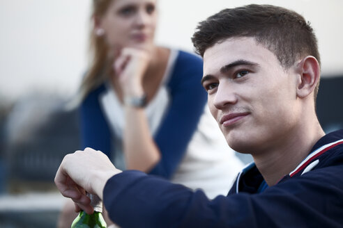 Portrait of young man with girlfriend in background - FEXF000018
