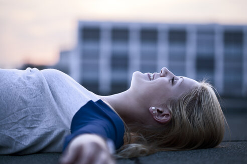 Young woman lying on flat roof - FEXF000015