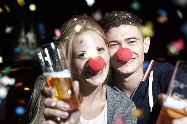 Deutschland, Nordrhein-Westfalen, Köln, junges Paar mit Clownsnasen beim Anstoßen - FEXF000003