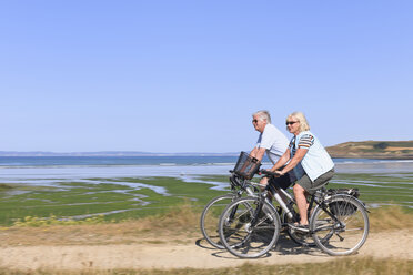 Frankreich, Bretagne, Finistere, Seniorenpaar auf E-Bikes an der Küste - LA000146