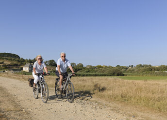 Frankreich, Bretagne, Finistere, Seniorenpaar auf E-Bikes an der Küste - LA000147