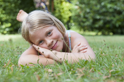 Lächelndes Mädchen im Gras liegend, lizenzfreies Stockfoto