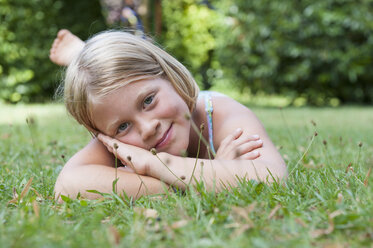 Smiling girl lying in grass - NHF001421