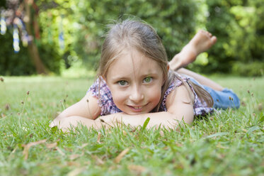 Smiling girl lying in grass - NHF001422