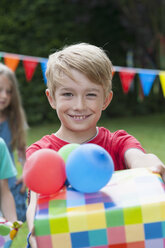 Boy handing over birthday present - NHF001439