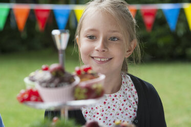 Girl looking at muffins on a birthday party - NHF001470