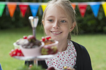 Mädchen schaut sich Muffins auf einer Geburtstagsfeier an - NHF001470