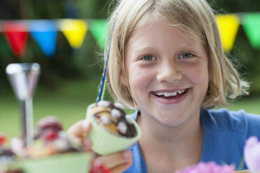 Happy girl eating muffin on a birthday party - NHF001434