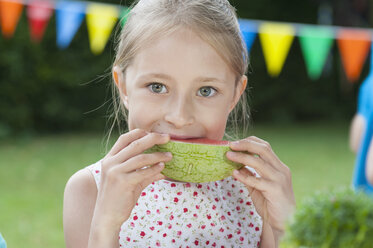 Glückliches Mädchen isst Wassermelone auf einer Geburtstagsparty - NHF001436