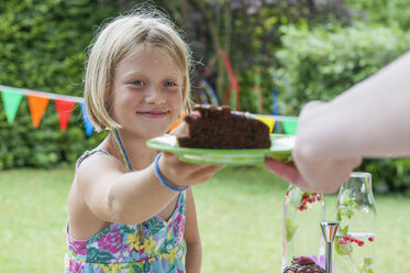 Mädchen erhält ein Stück Kuchen auf einer Geburtstagsparty - NHF001451