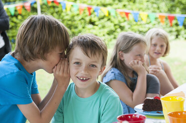 Two boys whispering on a birthday party - NHF001454