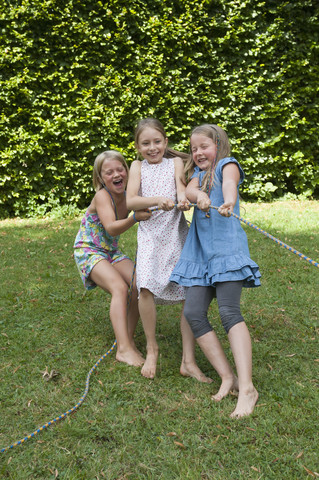 Girls playing tug-of-war on a birthday party stock photo