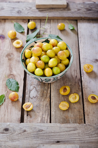Mirabelles in a bowl on a wooden tray stock photo