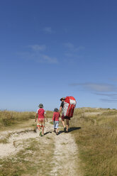 France, Bretagne, Landeda, Father with two sons walking in dune - LAF000159