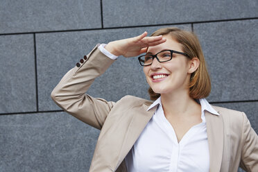 Germany, Businesswoman shielding eyes - RKNF000151