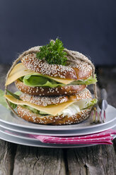 Two sesame bagels with Gouda and lettuce leaf, studio shot - ODF000472