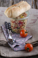 Couscous salad in glass jar with baguette bread and tomatoes, close up - ODF000476