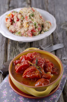 Eingelegte Tomaten mit Knoblauch und Rosmarin, im Hintergrund Couscoussalat - ODF000480