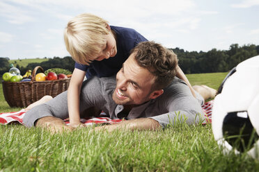 Deutschland, Köln, Vater und Sohn spielen auf einer Picknick-Decke - PDF000396