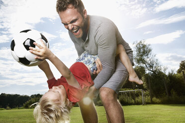 Germany, Cologne, Father and son playing soccer - PDF000402