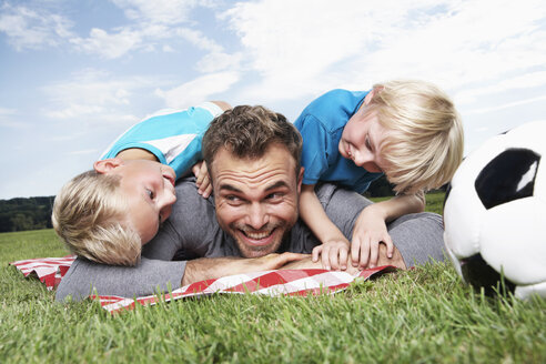 Germany, Cologne, Father and sons playing soccer - PDF000404