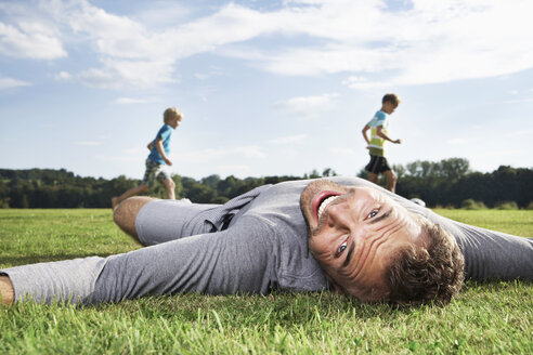 Germany, Cologne, Father and sons playing soccer - PDF000406