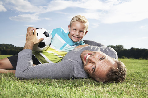 Germany, Cologne, Father and son playing soccer stock photo