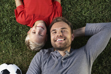 Germany, Cologne, Father and son lying in meadow - PDF000415