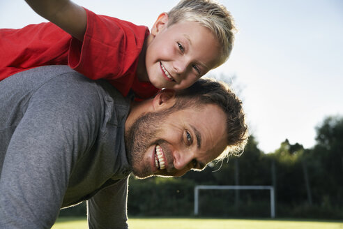 Germany, Cologne, Father carrying son on back, smiling - PDF000416