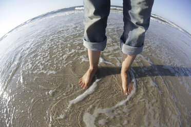 Deutschland, Niedersachsen, Ostfriesland, Langeoog, Füße einer Frau am Strand - JATF000337