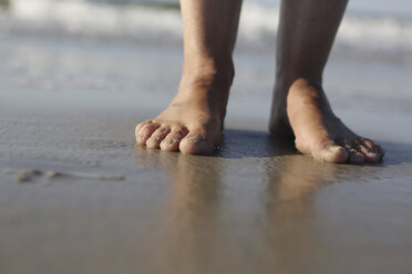 Germany, Lower Saxony, East Frisia, Langeoog, feet of a woman at the beach - JATF000291