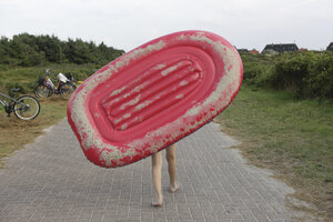 Deutschland, Niedersachsen, Ostfriesland, Langeoog, Junge mit Schlauchboot - JAT000342